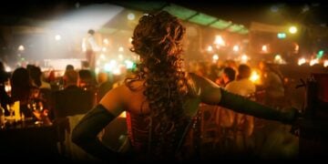 Cabaret performer seen from inside a candlelit Parisian club