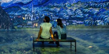 Visitors sitting inside an immersive art gallery at Frameless