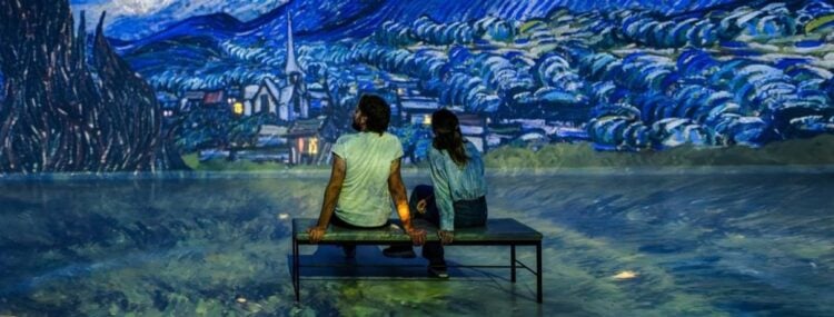 Visitors sitting inside an immersive art gallery at Frameless