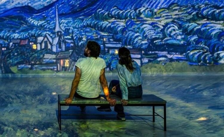 Visitors sitting inside an immersive art gallery at Frameless
