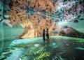 Two people standing inside FRAMELESS immersive art experience