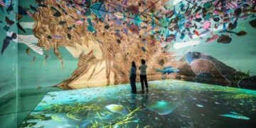 Two people standing inside FRAMELESS immersive art experience