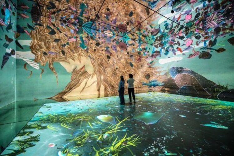 Two people standing inside FRAMELESS immersive art experience