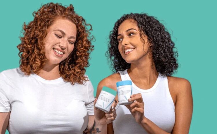 Two women smiling while holding Happy V wellness products