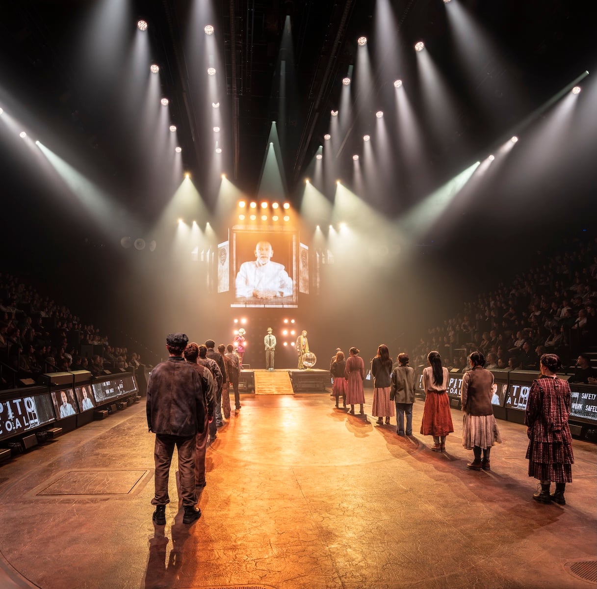 The Hunger Games on Stage cast in a dramatic ensemble scene