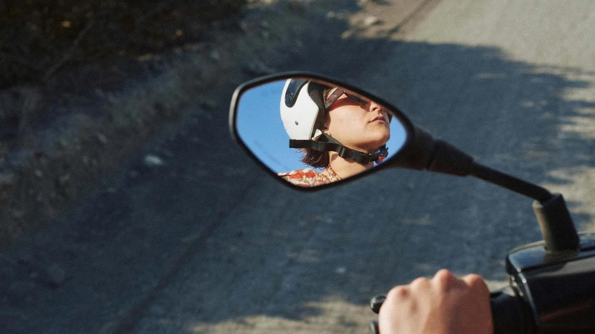 Viajero en moto visto desde el espejo retrovisor