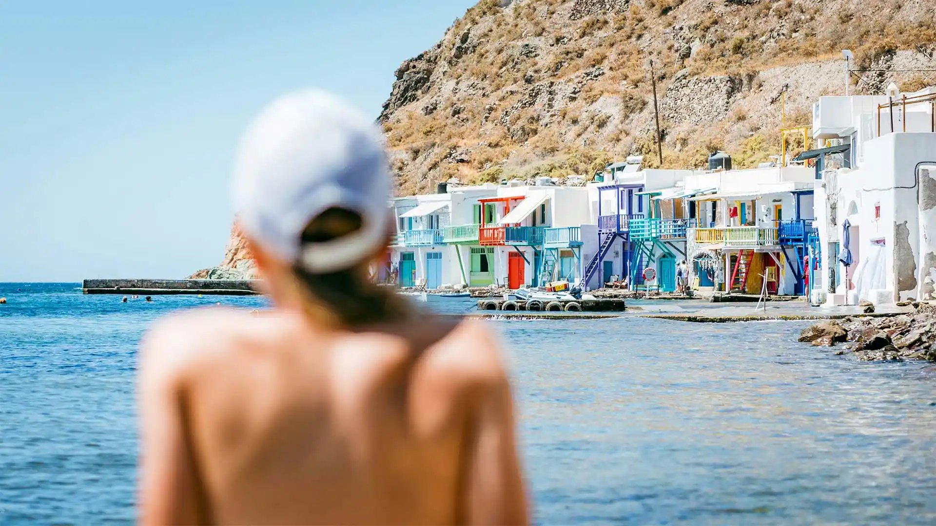 Mujer contemplando un pueblo junto al mar
