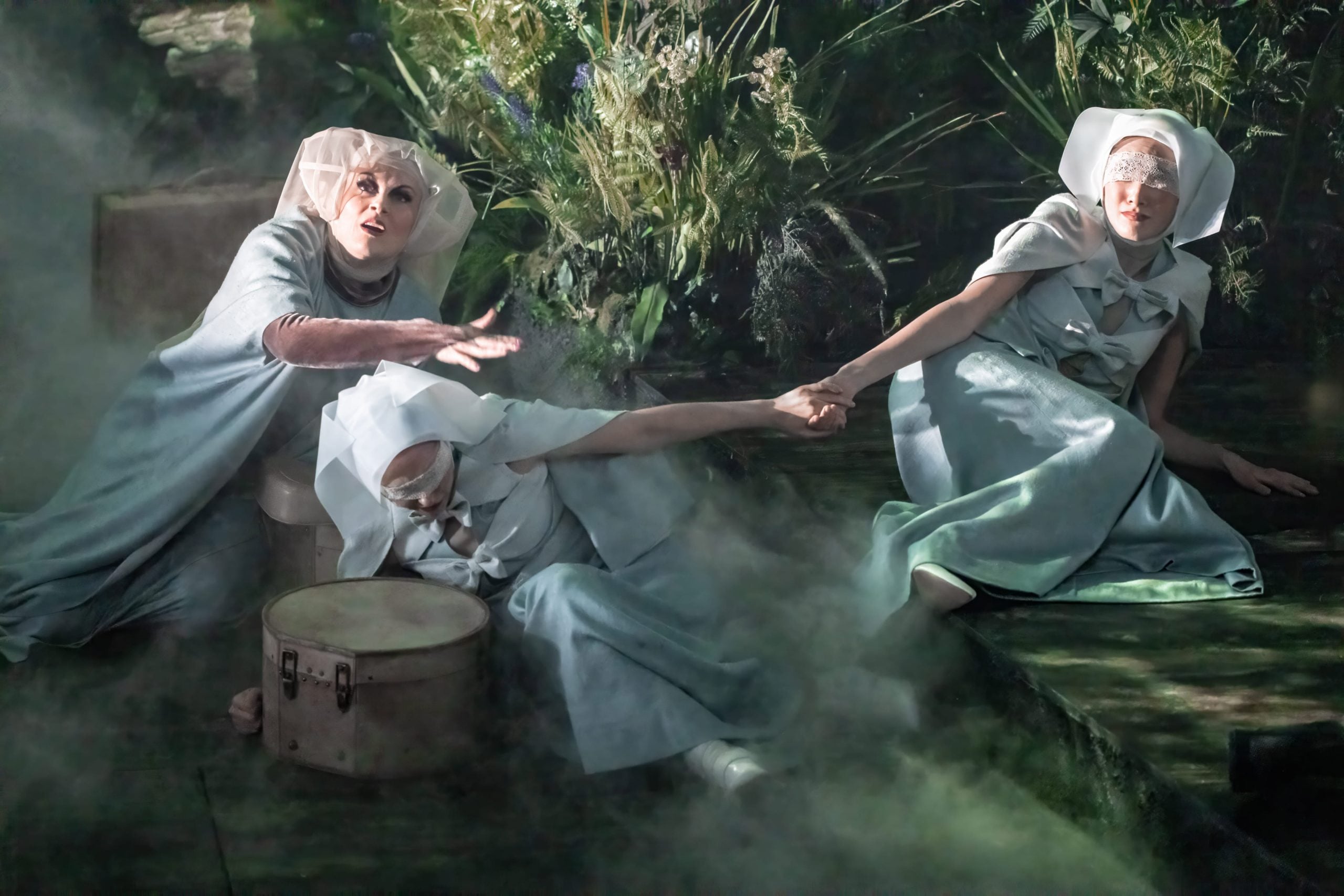 Into the Woods performers on stage in a theatrical forest scene