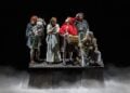 Into the Woods performers on a dark theatrical stage