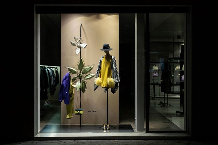 Schaufenster einer Julian Fashion Boutique mit gelbem Kleid und kuratierter Designer-Auswahl