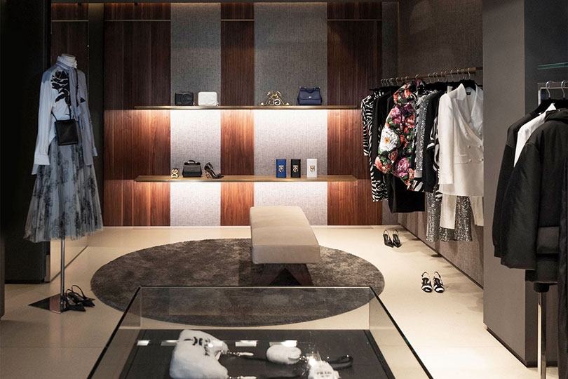 Scaffali illuminati con borse e accessori nella boutique Julian Fashion