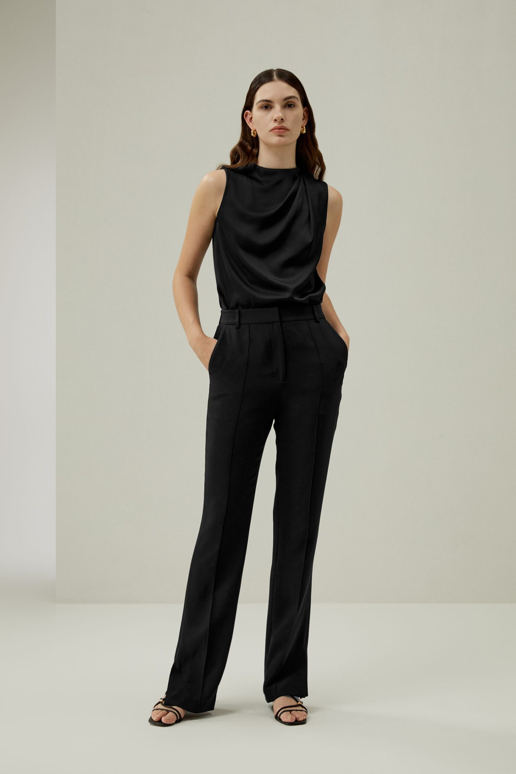 Model in schwarzem Lilysilk Outfit vor hellem Hintergrund