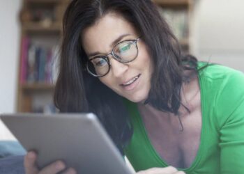 Frau nutzt ein Tablet in einer hellen Alltagsszene