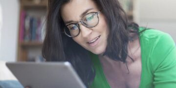 Frau nutzt ein Tablet in einer hellen Alltagsszene