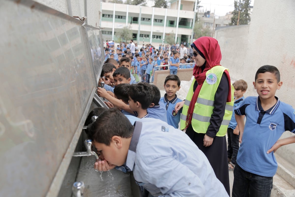 Schoolchildren drinking from taps at a Muslim Aid water project