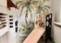 Playroom with jungle wall mural and a white slide