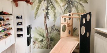 Playroom with jungle wall mural and a white slide