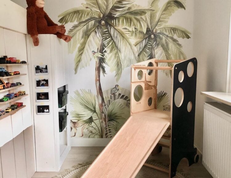 Playroom with jungle wall mural and a white slide