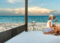 Coppia rilassata su un lettino sulla spiaggia di un resort Ocean