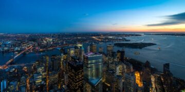 Wide sunset panorama of New York Harbor and Lower Manhattan from above