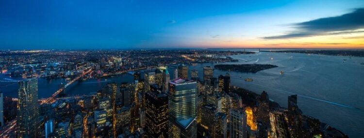 Wide sunset panorama of New York Harbor and Lower Manhattan from above