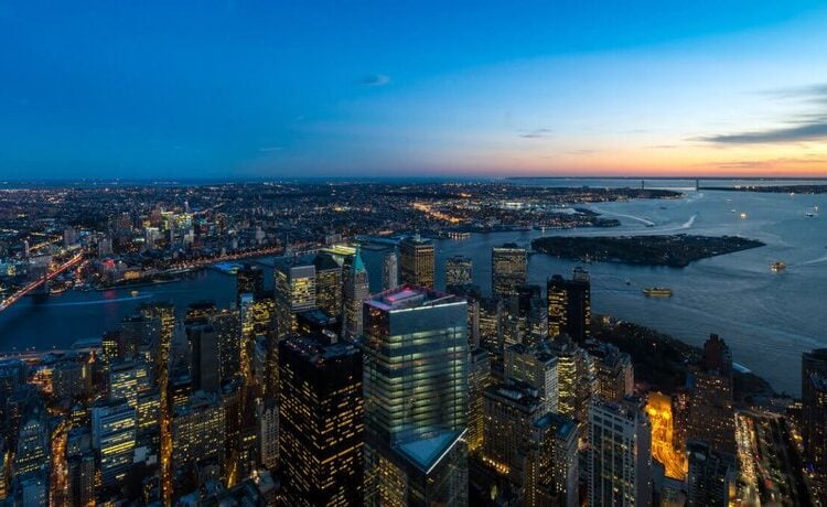 Wide sunset panorama of New York Harbor and Lower Manhattan from above