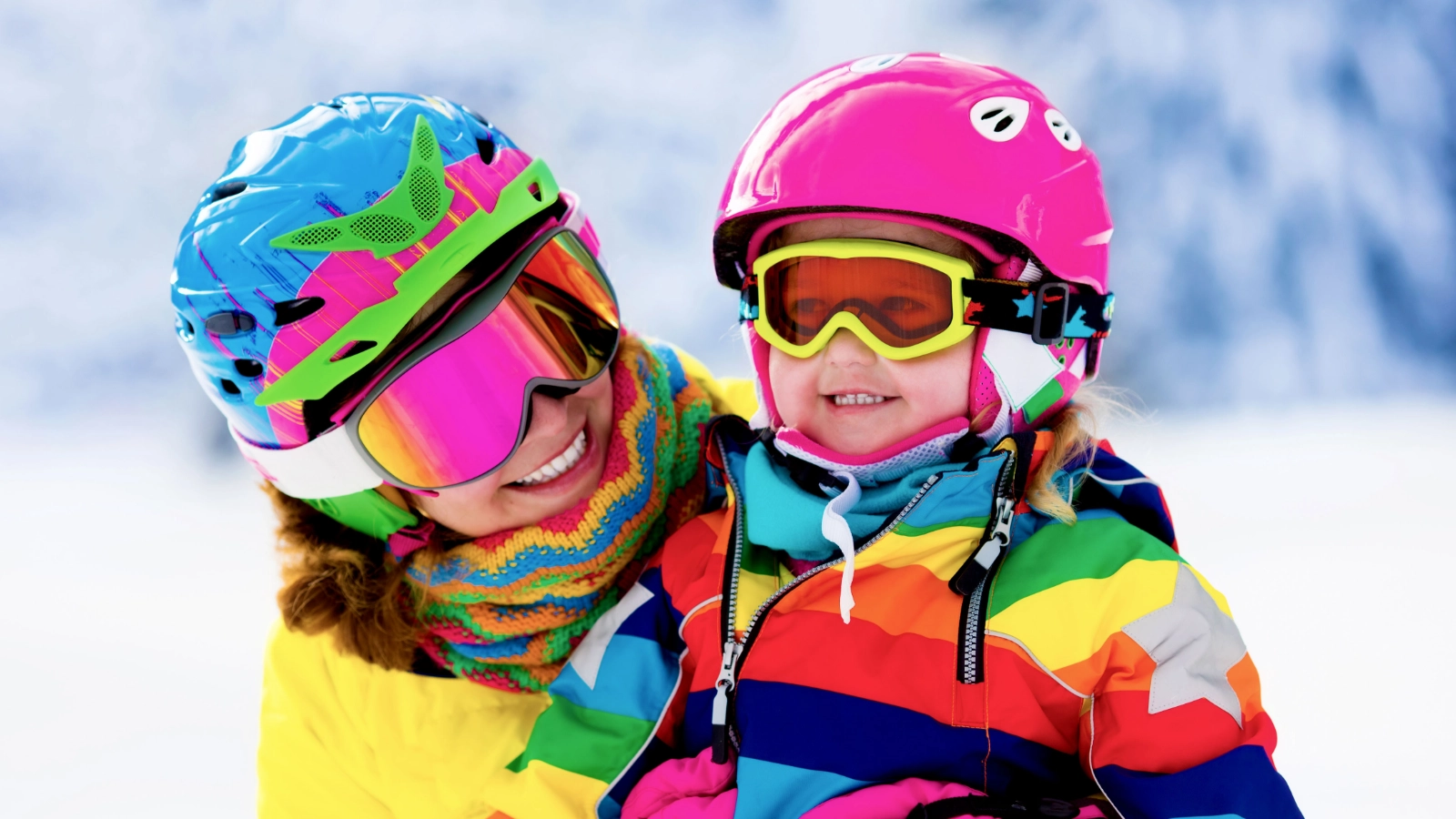 Two people in colourful ski clothing in a snowy setting