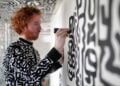 Artist painting a black and white patterned wall at The View from The Shard