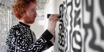 Artist painting a black and white patterned wall at The View from The Shard