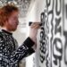 Artist painting a black and white patterned wall at The View from The Shard
