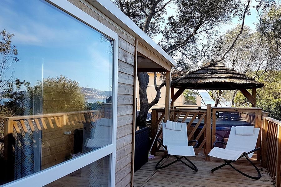 Terrasse einer Unterkunft mit Liegestühlen beim Camping Clair de Lune