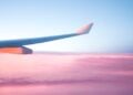 Airplane wing above clouds during a travel journey