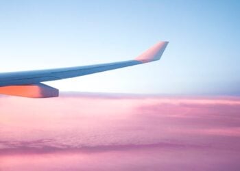 Airplane wing above clouds during a travel journey