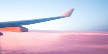 Airplane wing above clouds during a travel journey