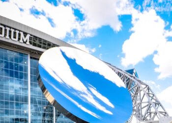 AT&T Stadium exterior with the Sky Mirror sculpture under a blue sky
