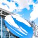 AT&T Stadium exterior with the Sky Mirror sculpture under a blue sky