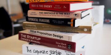 Pile de livres posée sur une table dans un intérieur lumineux