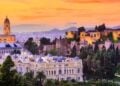 Warm sunset over Malaga rooftops for an autumn travel route