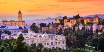 Warm sunset over Malaga rooftops for an autumn travel route