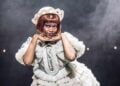Cabaret performer in a white costume on stage