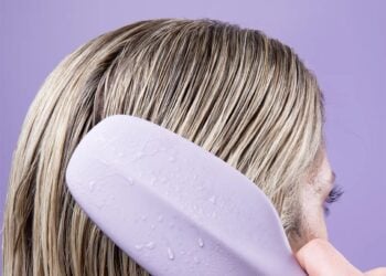 Person using the Cliphair Wet One detangling hairbrush