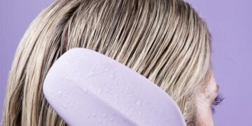 Person using the Cliphair Wet One detangling hairbrush