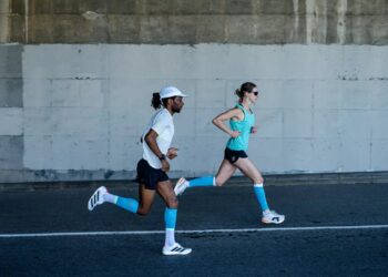 Zwei Läufer unter einer Brücke in Compressport Laufbekleidung