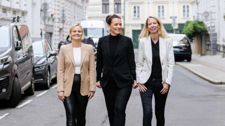 Drei Frauen gehen gemeinsam durch eine Straße