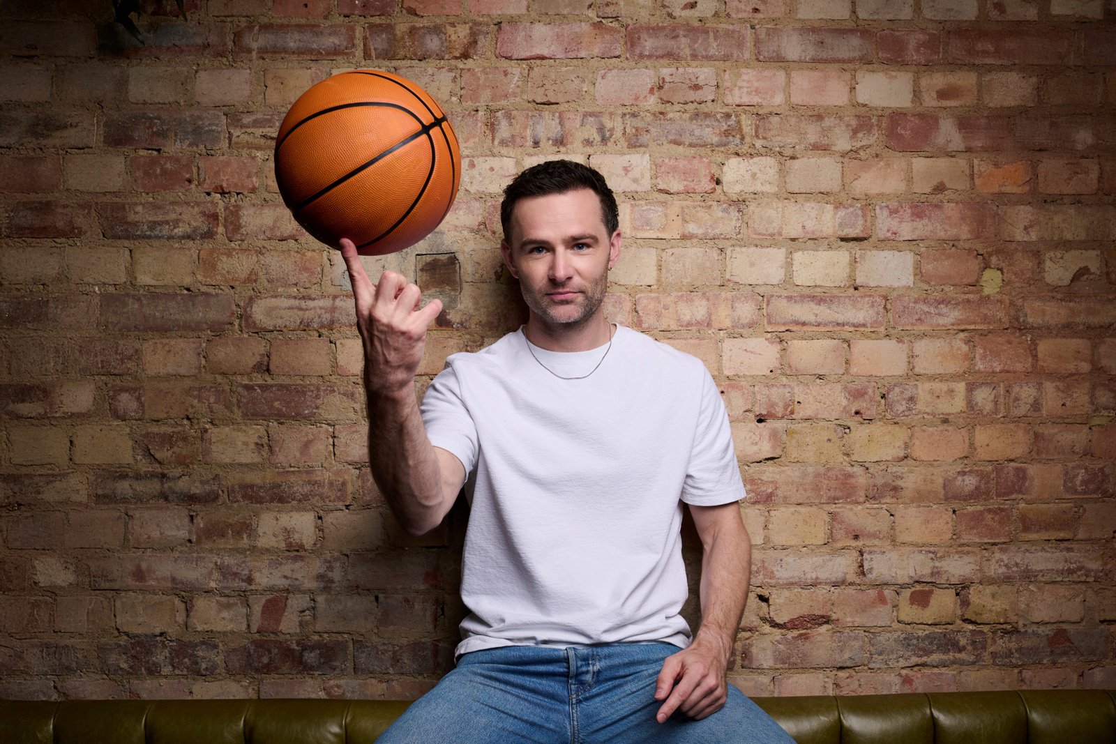 Performer spinning a basketball in a theatre publicity image
