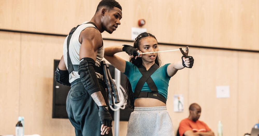 Performers rehearsing slingshot action for Hunger Games on Stage