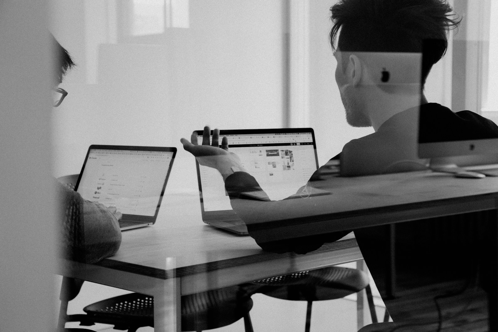 Personer som diskuterar vid laptops
