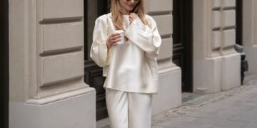 Frau im weißen Seidenoutfit in einer Editorial-Szene