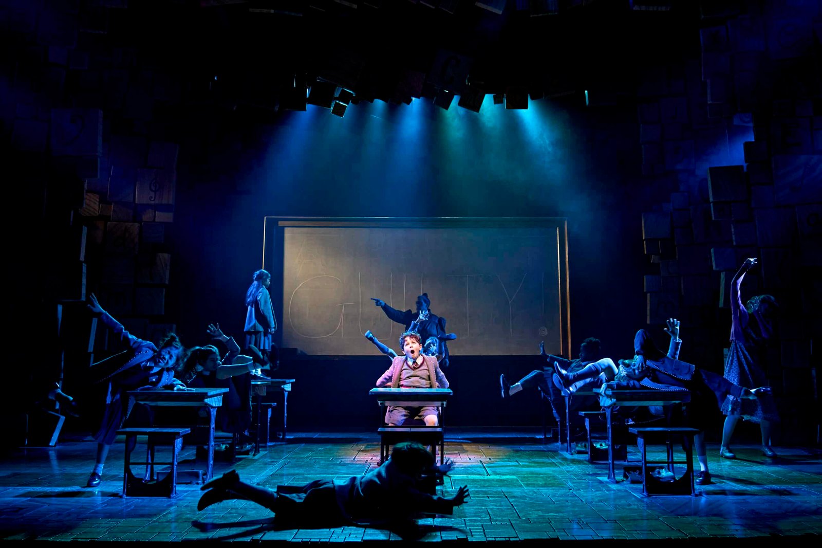Matilda The Musical performers around classroom desks
