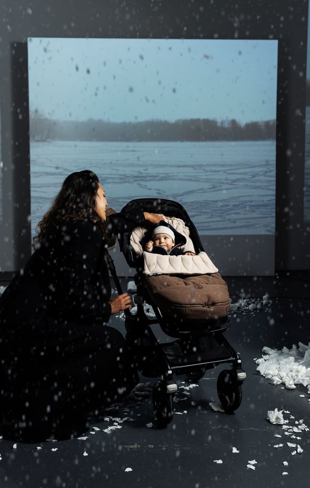 Baby in een kinderwagen met voetenzak tijdens een wandeling